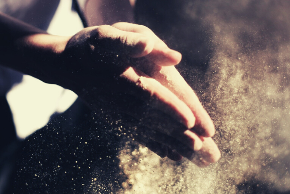 Persons' hands clapping dust away